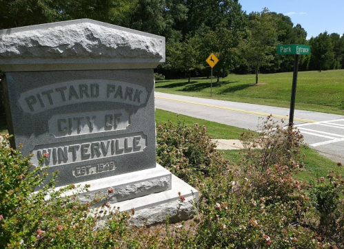 Stone monument for Pittard Park in Winterville, with a street sign for Park Drive visible in the background.