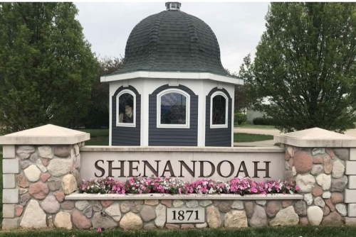 A decorative stone sign reading "Shenandoah" with a gazebo and colorful flowers in front.