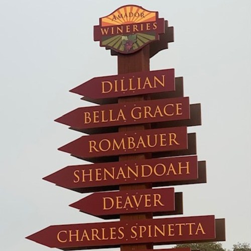 Signpost displaying directions to various wineries: Dillan, Bella Grace, Rombauer, Shenandoah, Deaver, Charles Spinetta.