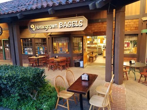 Exterior of Homegrown Bagels shop with outdoor seating, closed sign, and warm, inviting atmosphere.