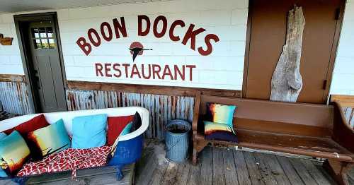 A cozy outdoor seating area at Boon Docks Restaurant, featuring colorful pillows and rustic decor.