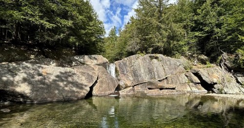 buttermilk falls cascades over rocks into a swimming hole in vermont