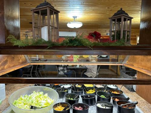 A salad bar with various toppings in bowls, decorated with lanterns and greenery above.