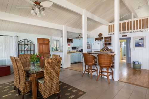 Bright, open-concept living space with a dining area, kitchen, and natural light from large windows. Cozy and inviting atmosphere.