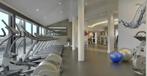 Modern gym interior featuring treadmills, exercise equipment, and a large window with a view.