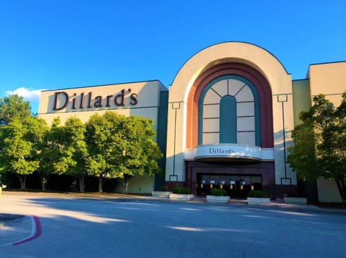 Exterior of a Dillard's department store with a clear blue sky and trees in front.