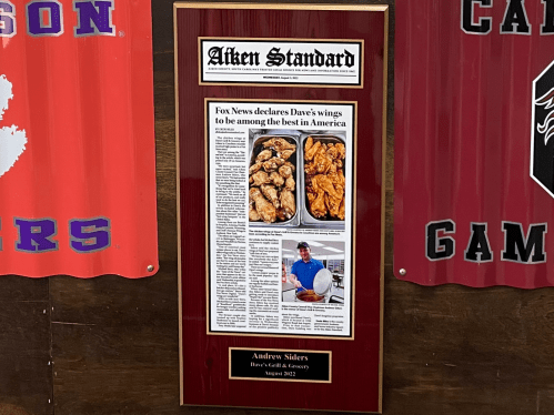 A plaque featuring an article about Dave's wings, recognized by Fox News as among the best in America.