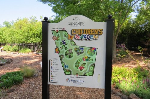 Sign for Glencairn Garden's Children's Garden, featuring a colorful map with various attractions and pathways.