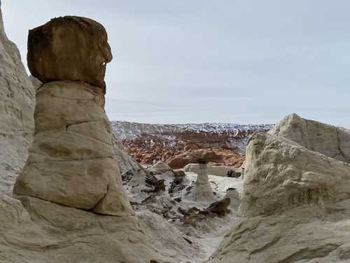 A rocky landscape featuring unique stone formations and layered cliffs under a cloudy sky.