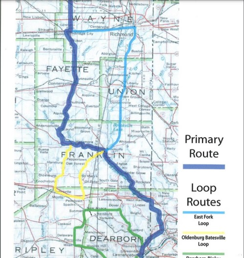 Map showing a primary route in blue and loop routes in yellow and green, with labeled towns and counties.
