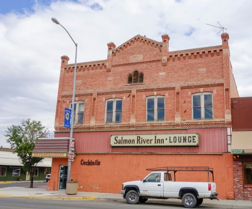 Historic brick building with "Salmon River Inn Lounge" sign, featuring a white pickup truck parked in front.