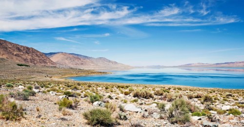 View of blue lake surrounded by desert landscape