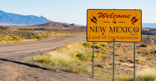 Welcome to New Mexico sign along the road at the state border in Teec Nos Pos, Arizona