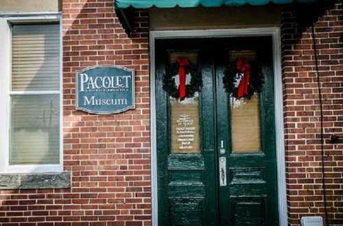 Entrance of the Pacolet Museum in South Carolina, featuring green doors and festive wreaths with red bows.