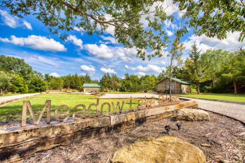 Sign for Meadow Lake Park with a scenic view of trees and a blue sky in the background.