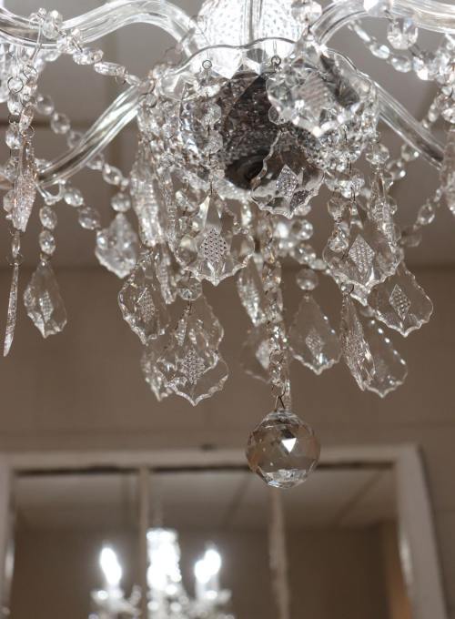 A close-up of a crystal chandelier with sparkling glass droplets and intricate designs.