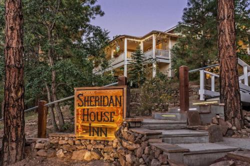 Sign for Sheridan House Inn with a rustic design, surrounded by trees and a welcoming entrance.