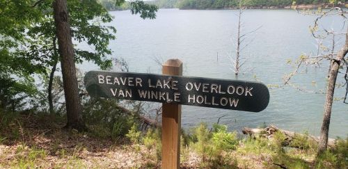 Sign for Beaver Lake Overlook at Van Winkle Hollow, surrounded by trees and a calm lake in the background.