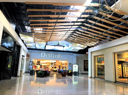 Interior view of a mall featuring Dillard's store, with a modern ceiling design and seating area.