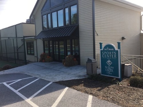 Exterior view of the Sleepy Creek Spa and Sports Center, featuring a sign and seasonal decorations.