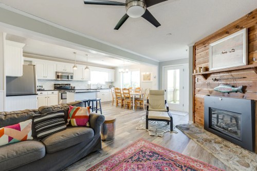 Cozy living area with a sofa, colorful pillows, a fireplace, and a dining space in a bright, modern kitchen.