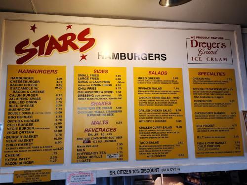 Menu board featuring hamburgers, salads, shakes, and specialties with prices listed. Includes a discount for seniors.
