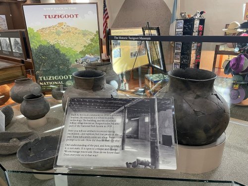 Display of ancient pottery at Tuzigoot National Monument, with an informational sign about the site's history.