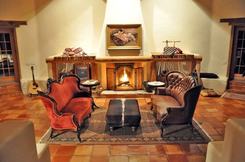 Cozy living room with two vintage sofas, a fireplace, and a decorative rug, creating a warm, inviting atmosphere.