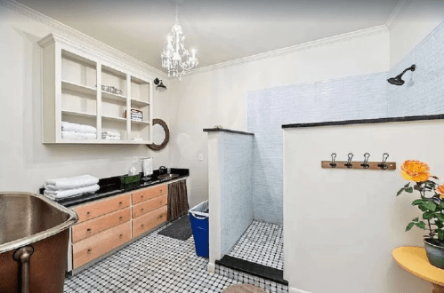 A modern bathroom featuring a walk-in shower, wooden cabinetry, a vintage tub, and a potted plant.