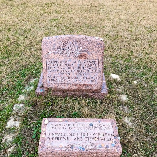 Two memorial stones on grass, honoring victims and officers lost in the Oklahoma City bombing on April 19, 1995, and February 28, 1994.