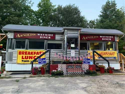 A vintage diner with a sign reading "Arnold's Wayside Diner," featuring banners for breakfast and lunch.