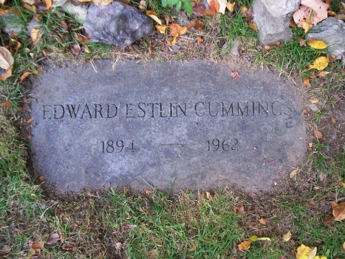 Gravestone of Edward Estlin Cummings, 1894-1962, surrounded by grass and fallen leaves.