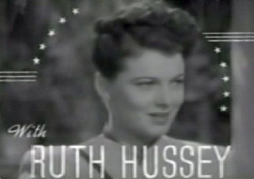 Black and white image featuring a woman with styled hair, captioned "With RUTH HUSSEY" and decorative stars.