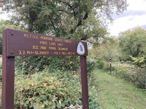 Sign for Kettle Moraine State Forest, Pike Lake Unit, indicating the Ice Age Trail segment and distance to Holy Hill.