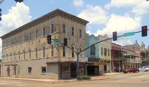 Historic buildings at an intersection, featuring a mix of architectural styles under a blue sky with clouds.