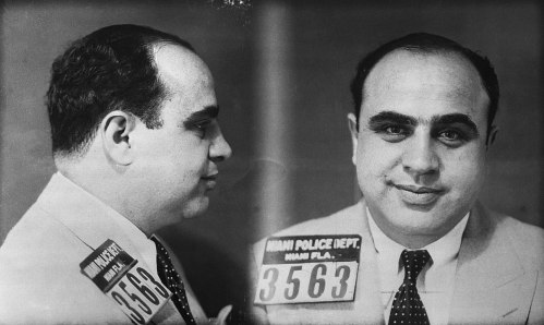 Mugshot of a man in a suit, facing forward and in profile, with police ID number 3563 from Miami Police Department.