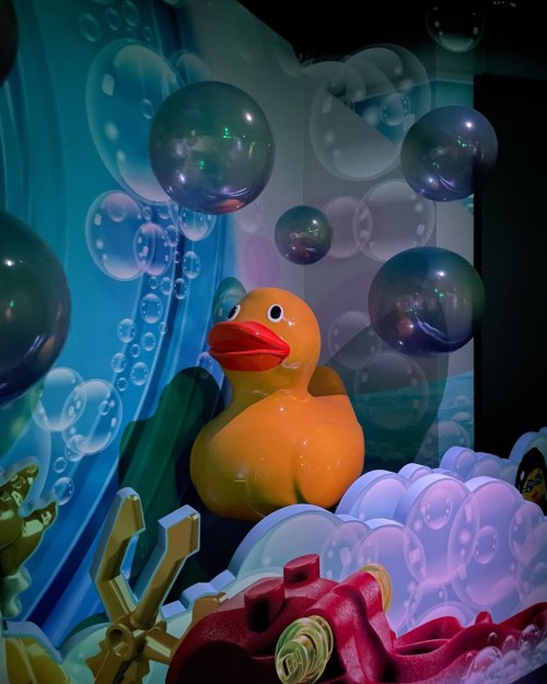 A large yellow rubber duck surrounded by colorful bubbles and a playful underwater mural.