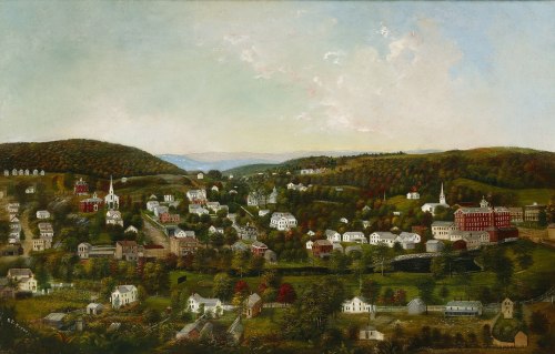 A scenic view of a small town nestled in rolling hills, featuring houses, churches, and lush greenery under a blue sky.