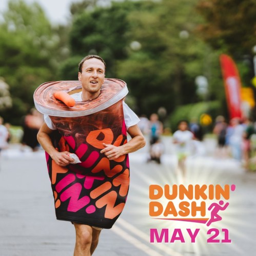 A man in a donut costume runs in a fun race, promoting the Dunkin' Dash event on May 21.