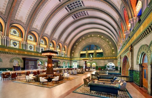 Elegant interior of a grand hall with arched ceilings, ornate decor, and stylish seating areas.