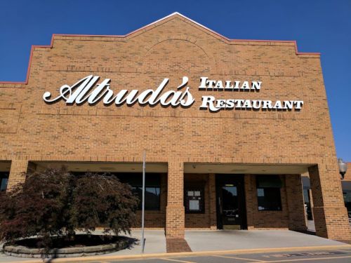 Exterior of Altruda's Italian Restaurant, featuring a brick facade and clear blue sky.