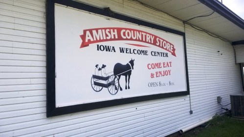Sign for "Amish Country Store" in Iowa, featuring a horse and buggy graphic. Open 8 AM - 8 PM.