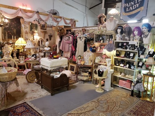 A vintage shop display featuring clothing, accessories, and decor in a charming, eclectic setting.