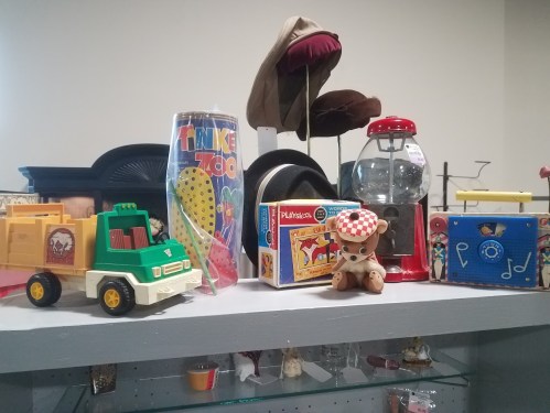 A display of vintage toys and collectibles, including a toy truck, a lantern, and a stuffed animal.