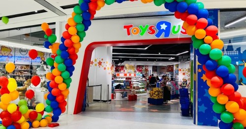 Colorful balloon arch at the entrance of a Toys "R" Us store, showcasing a vibrant and inviting atmosphere.