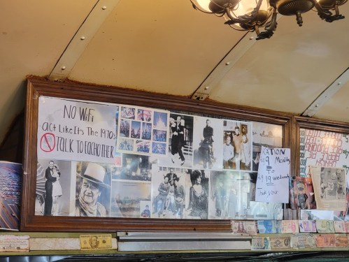 A wall display with vintage photos and signs, including a "No Wi-Fi" notice encouraging 1970s-style interaction.