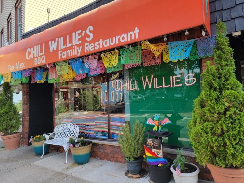 Exterior of Chili Willie's BBQ Family Restaurant, featuring colorful decorations and potted plants.