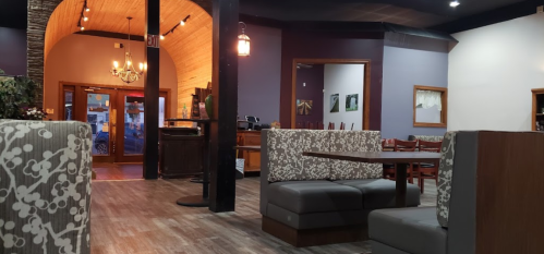Cozy restaurant interior with patterned seating, wooden accents, and warm lighting, creating an inviting atmosphere.