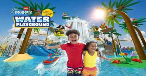 Two children joyfully play in a vibrant water playground at LEGOLAND New York, surrounded by LEGO-themed attractions.