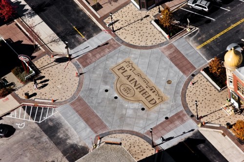 Aerial view of a town square in Plainfield, featuring decorative pavement and surrounding streets.
